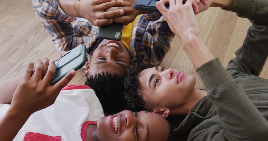 Teenagers Relaxing Together on Floor, Interacting with Smartphones - Free Images, Stock Photos and Pictures on Pikwizard.com