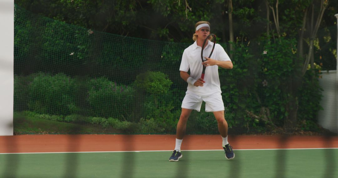 Male Tennis Player Preparing to Receive Serve on Outdoor Court - Free Images, Stock Photos and Pictures on Pikwizard.com