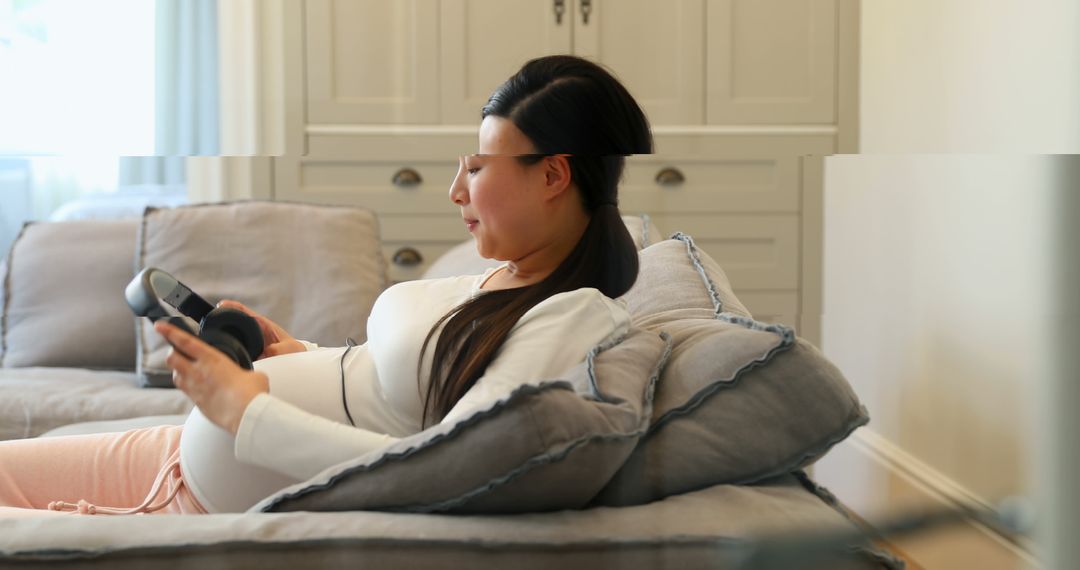 Pregnant Woman Relaxing on Couch Using Headphones for Baby Bonding - Free Images, Stock Photos and Pictures on Pikwizard.com