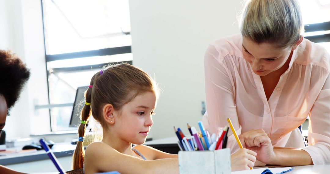 Teacher helping young student with classroom assignment - Free Images, Stock Photos and Pictures on Pikwizard.com