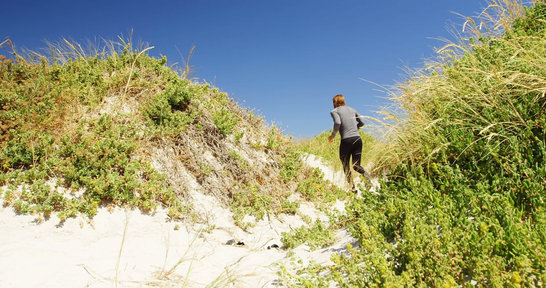 Woman Hiking Through Sandy Dunes on a Bright Day - Free Images, Stock Photos and Pictures on Pikwizard.com