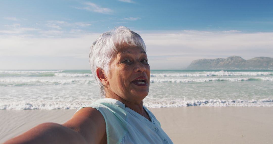 Senior Woman Taking Selfie at Beach on Sunny Day - Free Images, Stock Photos and Pictures on Pikwizard.com