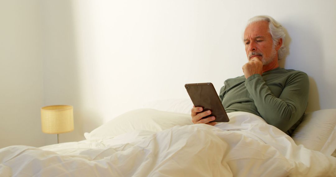 Senior Man Using Digital Tablet While Relaxing in Bed - Free Images, Stock Photos and Pictures on Pikwizard.com