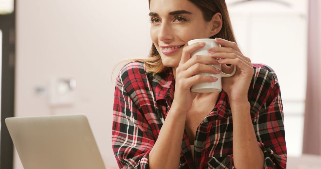 Woman Enjoying Coffee While Working on Laptop in Cozy Home - Free Images, Stock Photos and Pictures on Pikwizard.com