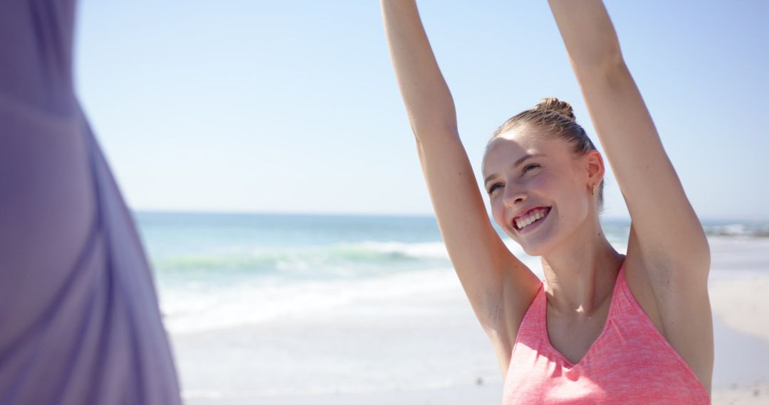 Joyful Woman Stretching on Sunny Beach with Ocean View
