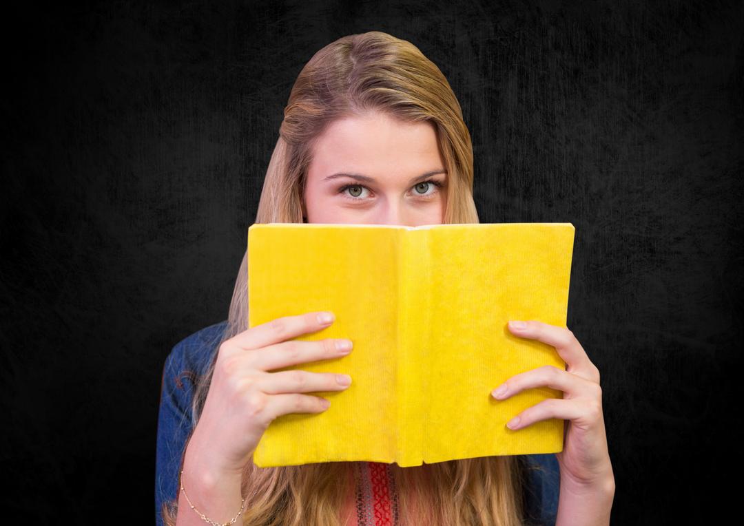 Woman holding a book against black background - Free Images, Stock Photos and Pictures on Pikwizard.com