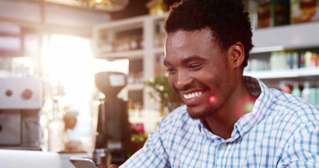 Smiling Man Using Smartphone at Cozy Cafe