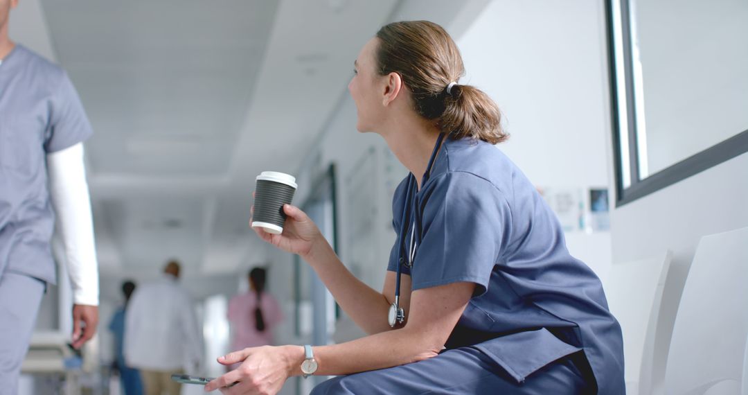 Nurse Relaxing with Coffee During Break in Hospital Hallway - Free Images, Stock Photos and Pictures on Pikwizard.com