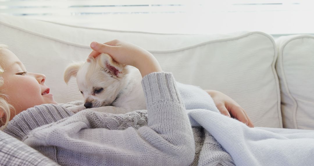 Tender Moment of a Girl and Her Small Dog Relaxing on Couch