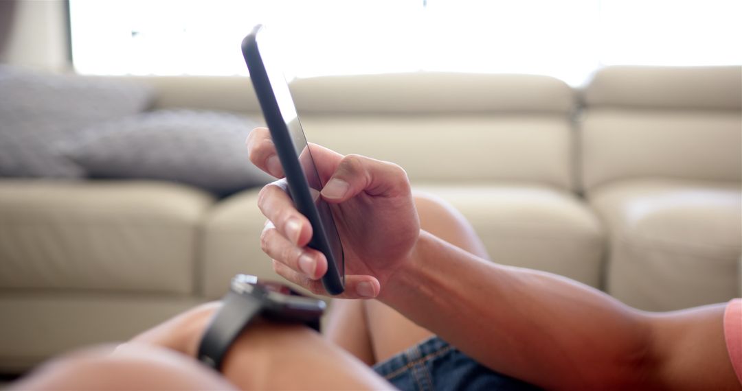 Young Adult Engaging with Smartphone Relaxing on Couch