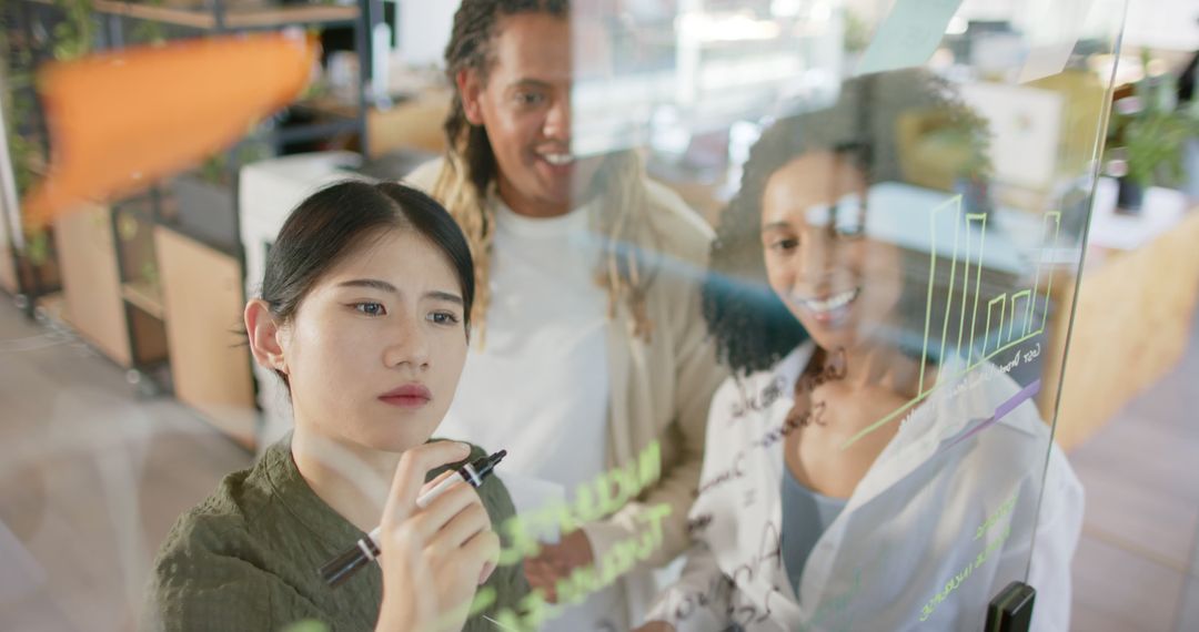 Team Collaborating and Brainstorming on Glass Board