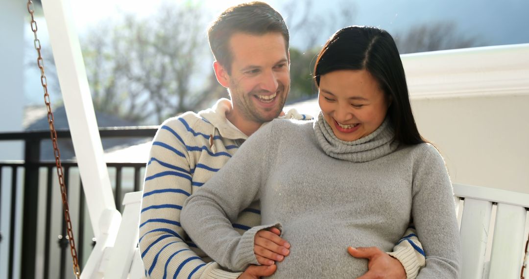 Mixed Race Couple Bonding On Porch Swing During Pregnancy - Free Images, Stock Photos and Pictures on Pikwizard.com