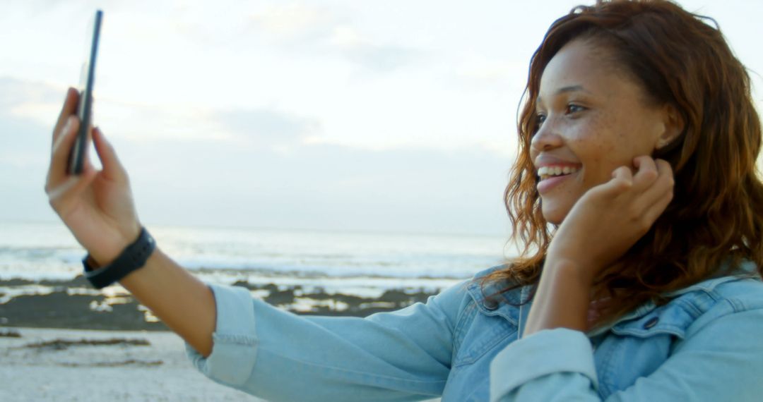 Woman Taking Selfie on Beach During Sunset - Free Images, Stock Photos and Pictures on Pikwizard.com