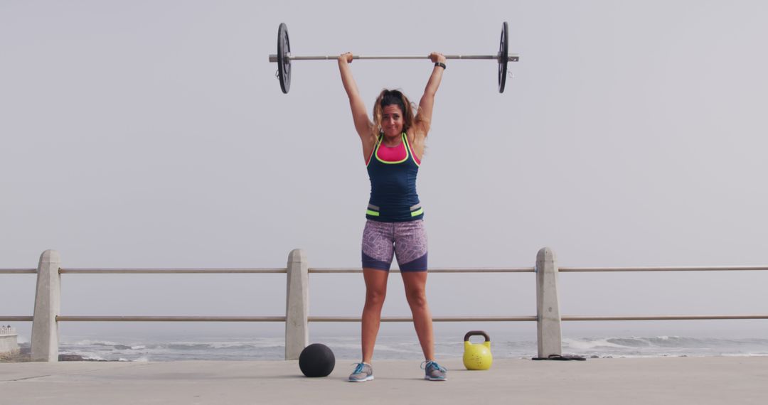 Female Athlete Lifting Barbell During Outdoor Workout by the Sea - Free Images, Stock Photos and Pictures on Pikwizard.com