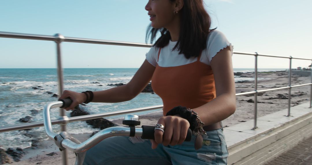 Young Woman Cycling on Seaside Boardwalk - Free Images, Stock Photos and Pictures on Pikwizard.com