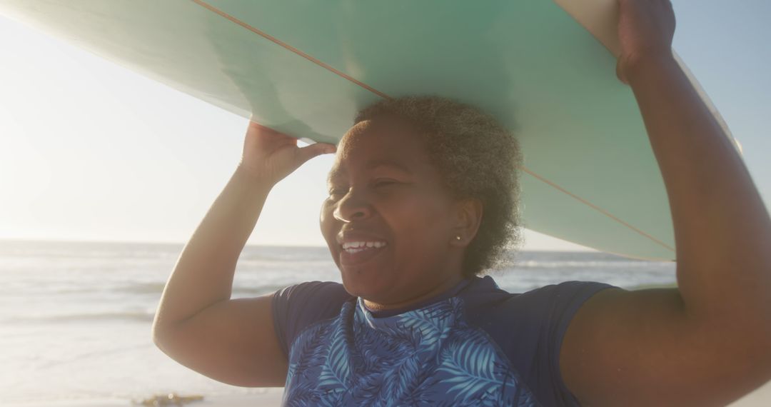 Smiling Senior Woman Carrying Surfboard on Beach at Sunset - Free Images, Stock Photos and Pictures on Pikwizard.com