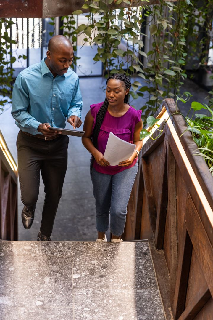 Professional Discussion on Office Staircase Surrounded by Greenery