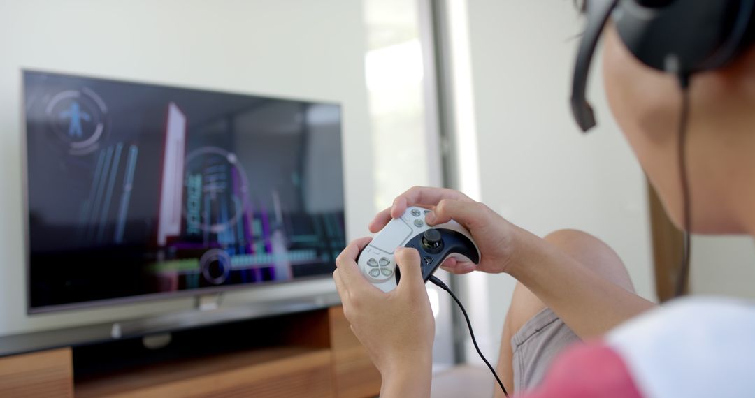 Focused Gamer Playing Console Video Game with Headphones