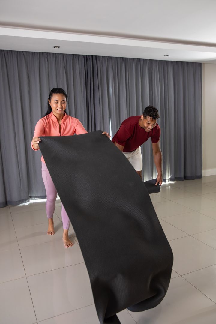 Diverse Couple Preparing Exercise Mat at Home for Fitness Routine