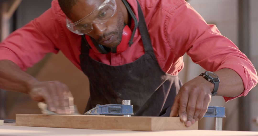Skilled African American Craftsman Sanding Wood Piece in Workshop