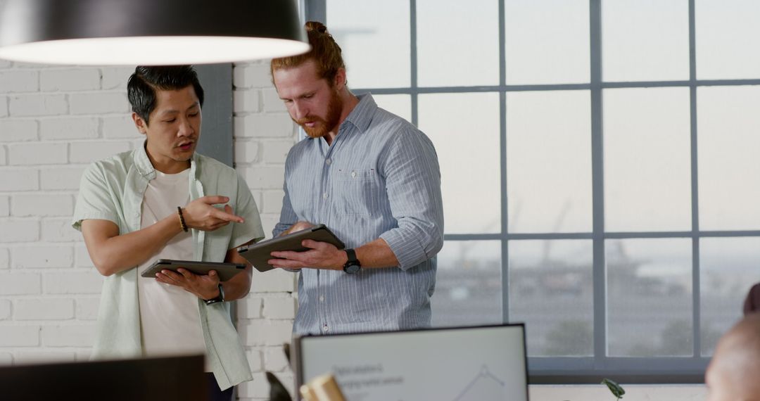 Diverse Professionals Collaborating with Digital Tablets in Modern Office