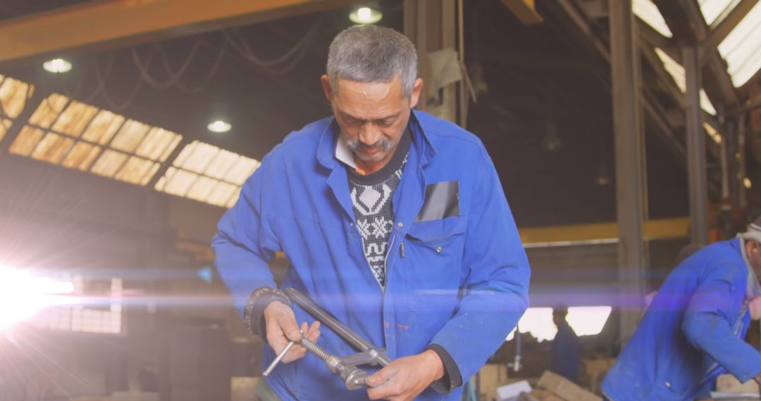 Biracial Male Mechanic Working in Industrial Workshop with Glowing Light