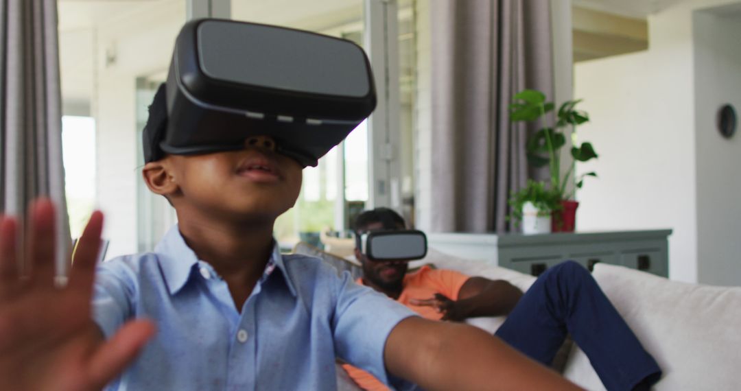 Father and son enjoying virtual reality experience at home - Free Images, Stock Photos and Pictures on Pikwizard.com