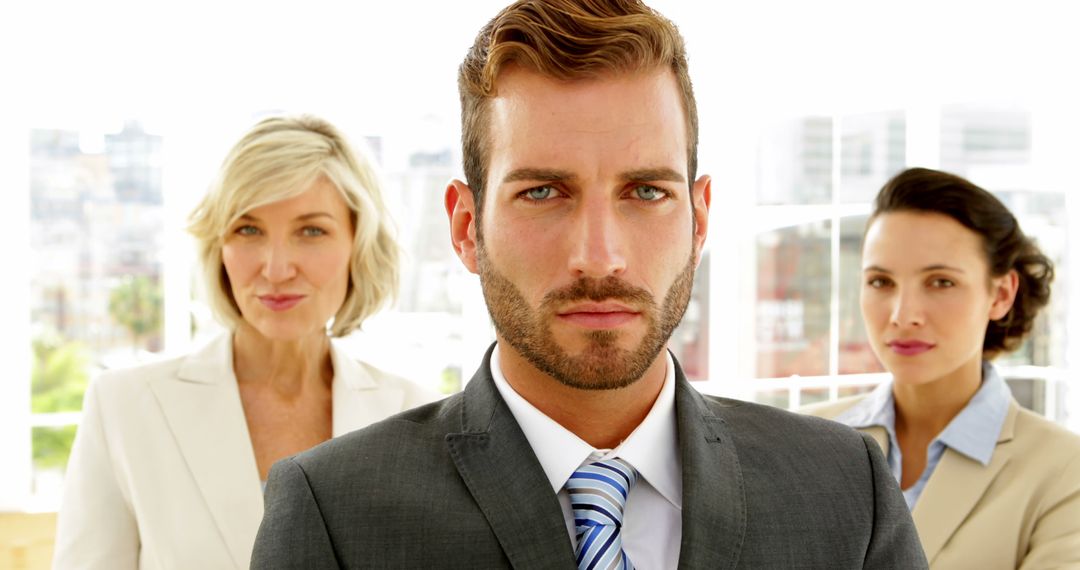 Confident Businessman Standing with Two Professional Businesswomen - Free Images, Stock Photos and Pictures on Pikwizard.com