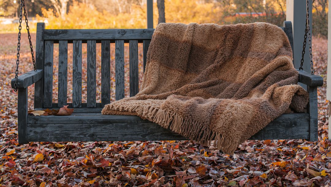 Cozy Wooden Swing Bench with Throw amidst Autumn Leaves