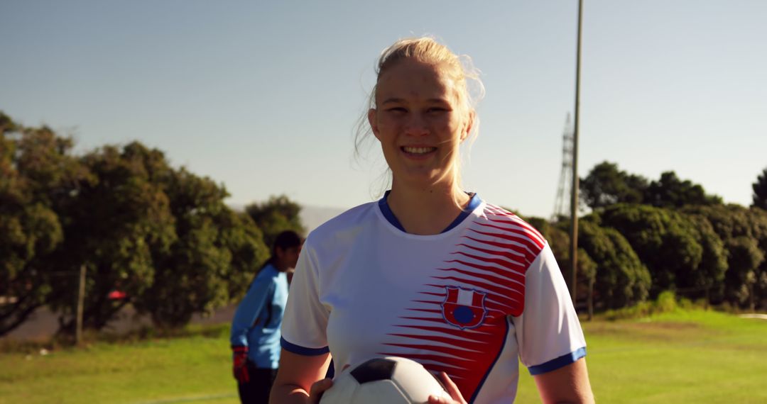 Female Soccer Player Smiling Holding Soccer Ball in Grass Field - Free Images, Stock Photos and Pictures on Pikwizard.com