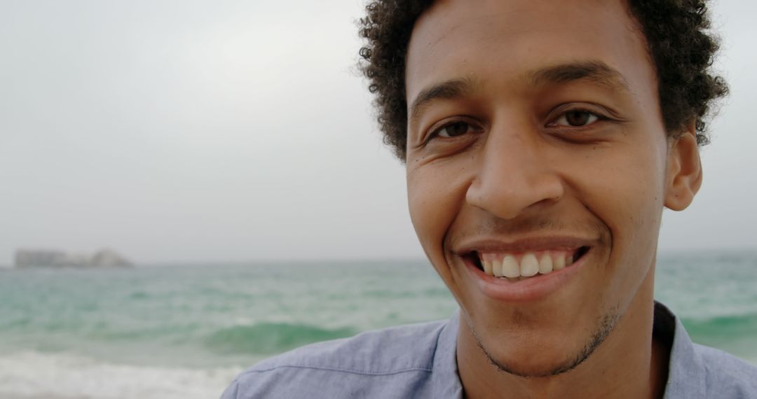 Smiling Young Man at Beachfront Smiling into Camera
