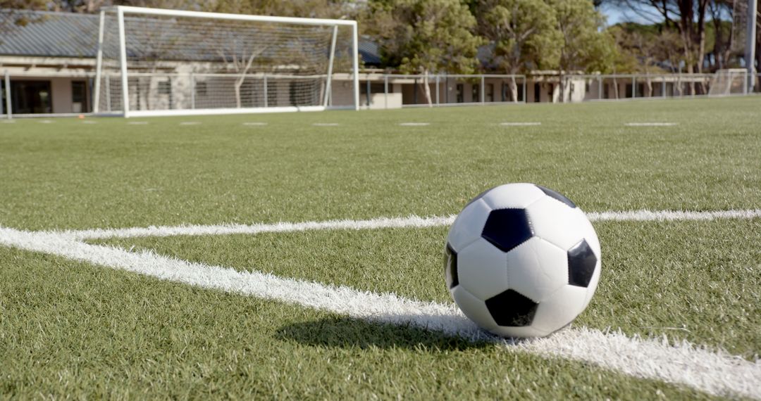 Soccer Ball on Synthetic Turf with Goalpost in Background