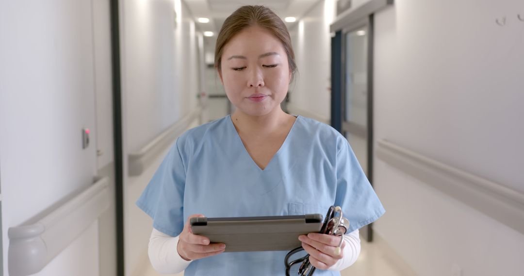 Nurse in Hospital Corridor Using Digital Tablet - Free Images, Stock Photos and Pictures on Pikwizard.com