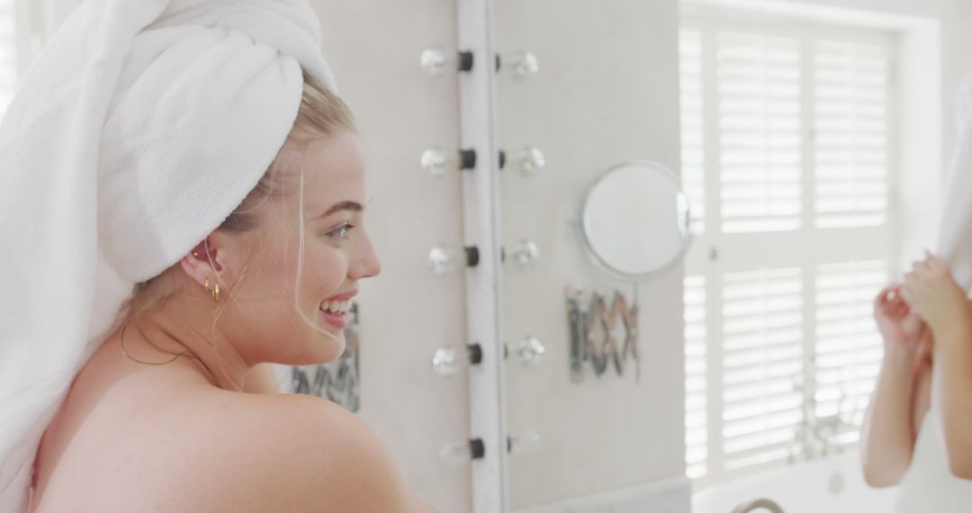 Young Woman with Towel on Head Smiling in Bathroom Mirror - Free Images, Stock Photos and Pictures on Pikwizard.com