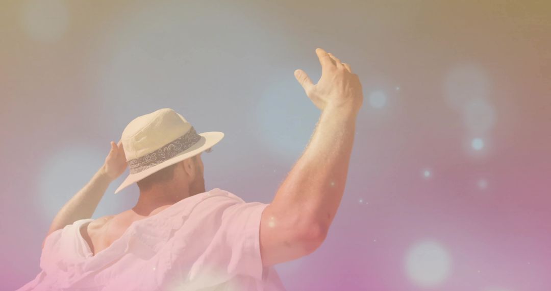 Man in Fedora and Pink Top Against Pastel Bokeh Backdrop