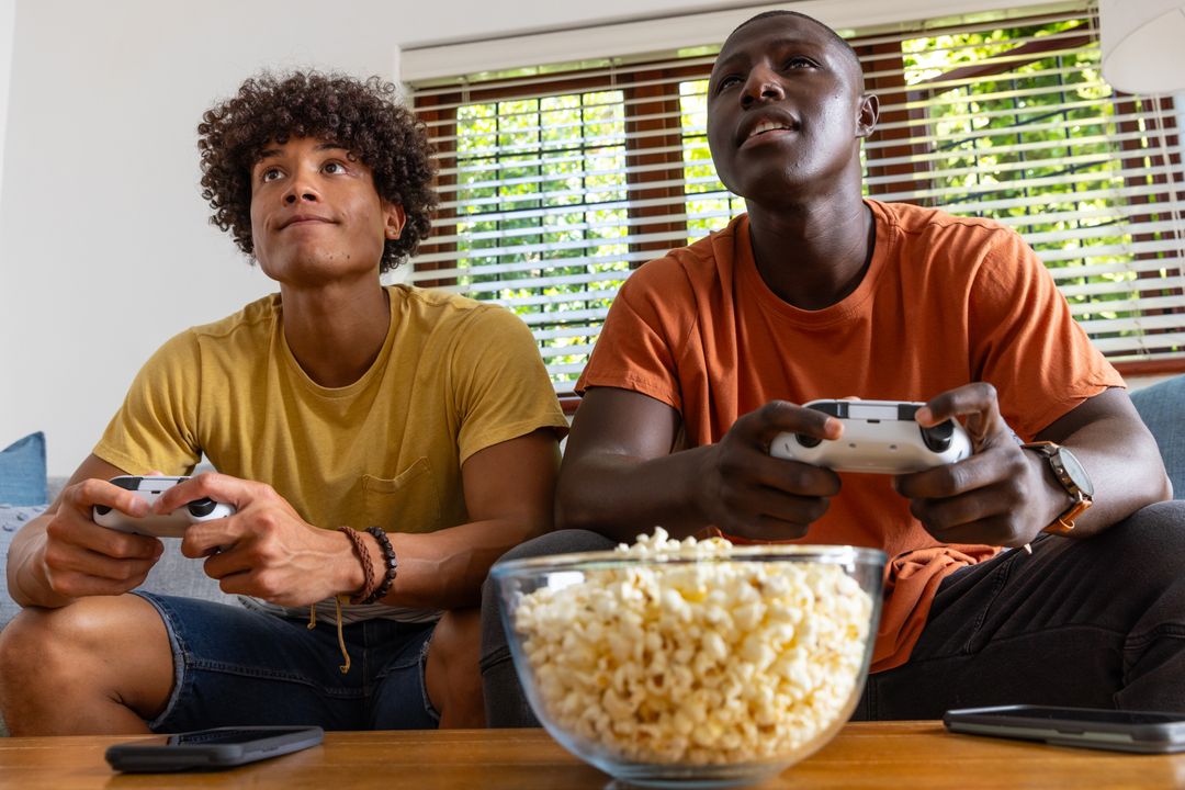 Diverse Friends Enjoying Video Games Together with Snacks