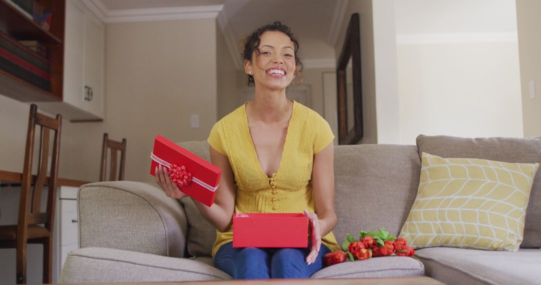Joyful Woman Unwrapping Gift During Video Call at Home