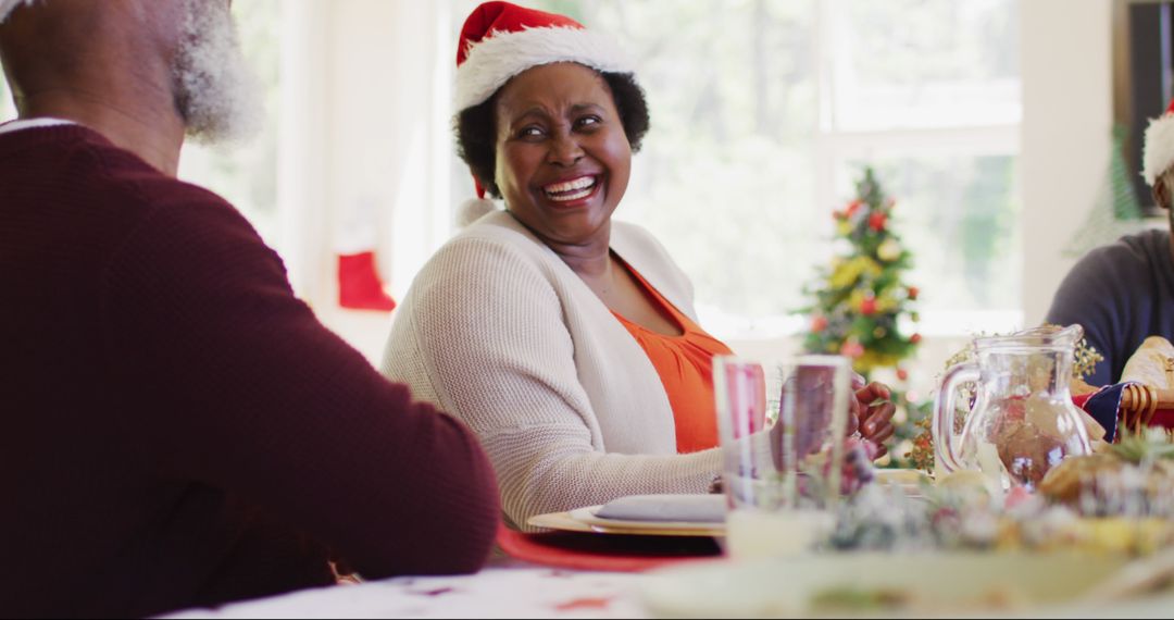 Happy Senior Woman in Santa Hat Enjoying Christmas Celebration - Free Images, Stock Photos and Pictures on Pikwizard.com