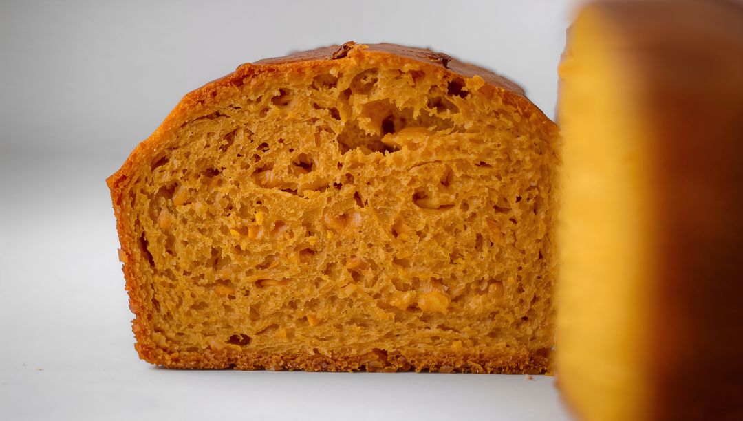 Sliced Golden Brioche Loaf with Glossy Crust and Moist Crumb on White Tabletop