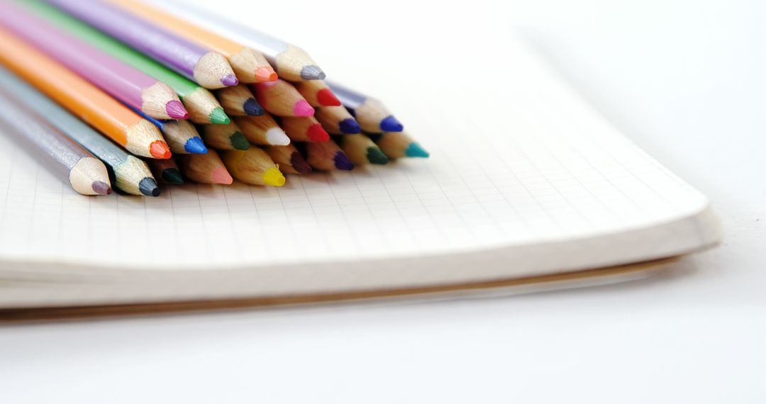 Stack of Colorful Pencils on Open Grid Notebook - Free Images, Stock Photos and Pictures on Pikwizard.com