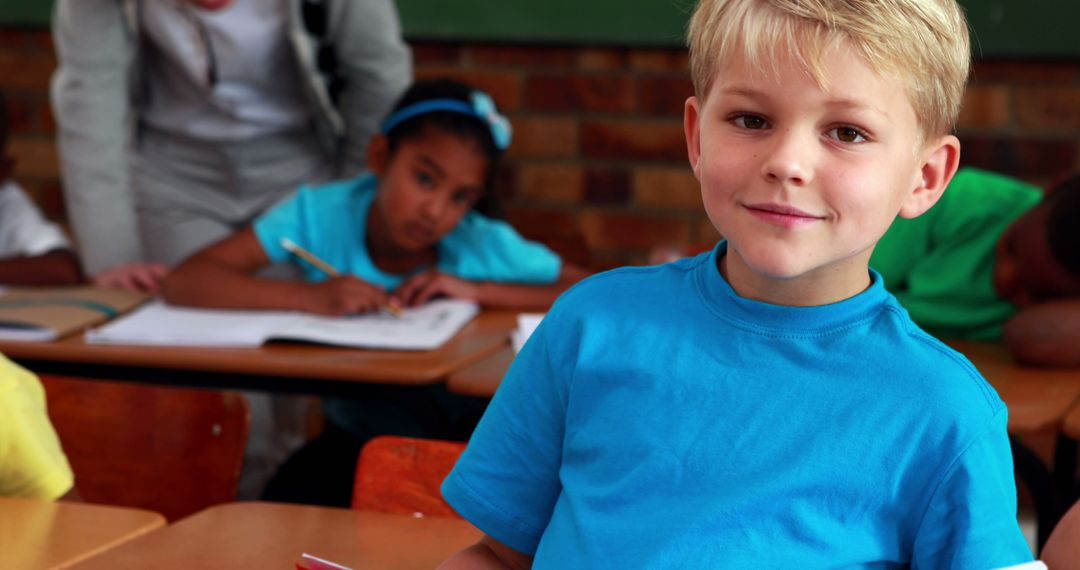 Smiling Blonde Child in Blue Shirt in Classroom - Free Images, Stock Photos and Pictures on Pikwizard.com