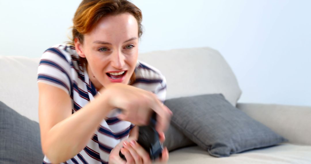 Woman Enthusiastically Playing Video Games on Sofa at Home - Free Images, Stock Photos and Pictures on Pikwizard.com