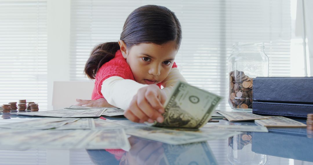 Young Girl Counting Money at Table with Coins and Bills Spreading - Free Images, Stock Photos and Pictures on Pikwizard.com