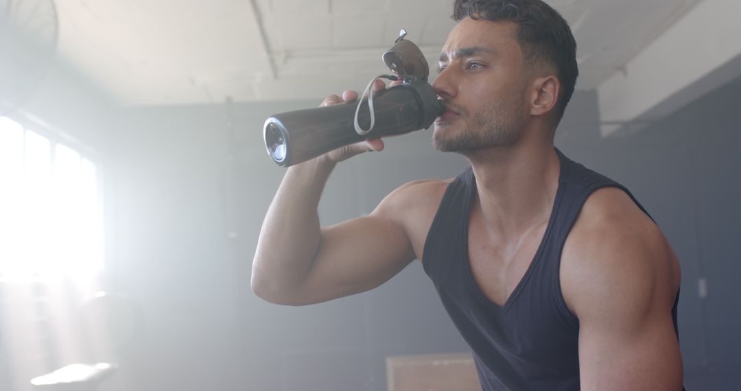 Fit Man Hydrating After Workout in Gym Setting