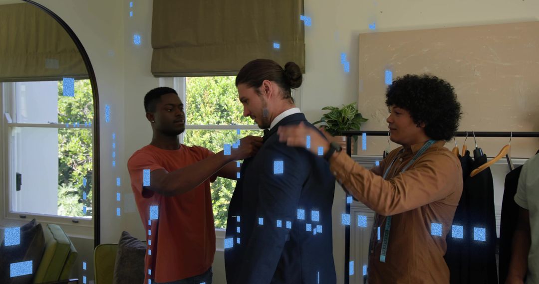 Tailoring team adjusting suit and collar during at home fitting with measuring tape and styling