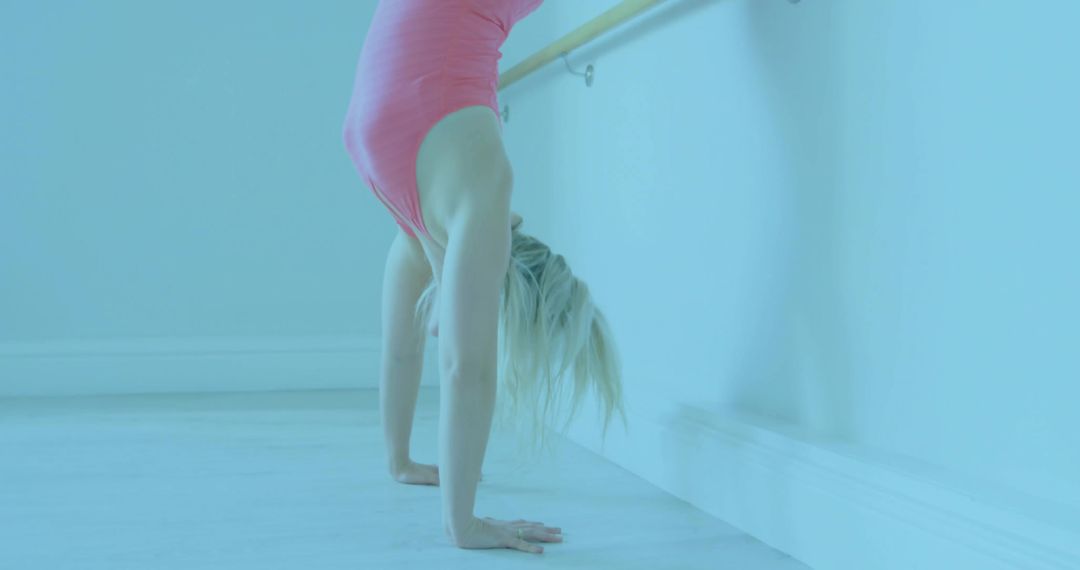 Female Dancer in Pink Leotard Performing Handstand at Ballet Studio
