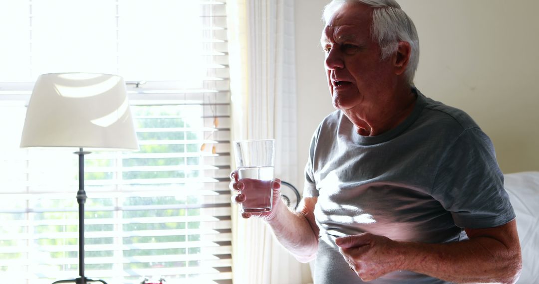 Senior Man Taking Medicine Near Sunny Bedroom Window - Free Images, Stock Photos and Pictures on Pikwizard.com