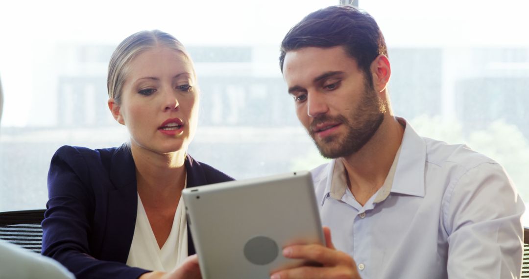 Coworkers Discussing Project Tablet in Office - Free Images, Stock Photos and Pictures on Pikwizard.com