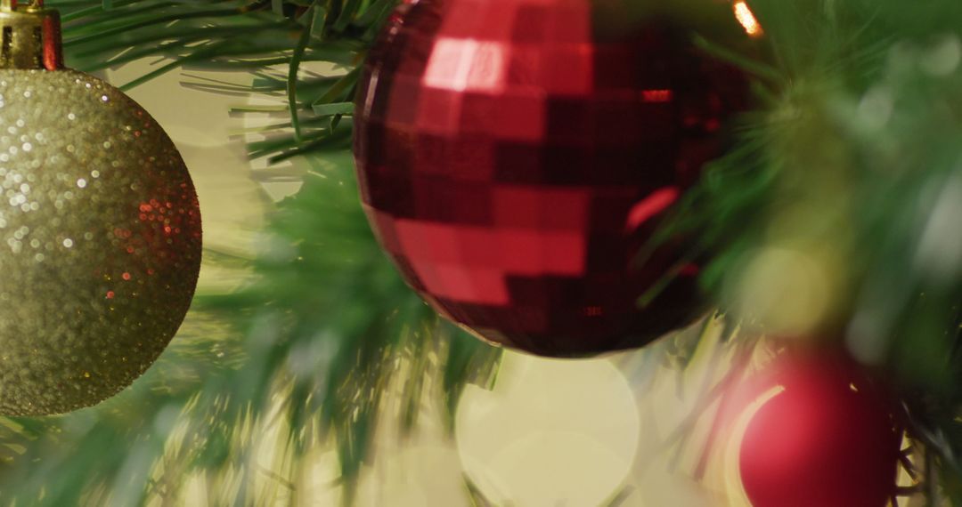 Festive Christmas Baubles on Tree Branch with Soft Lights