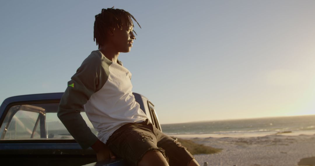 Young Man Relaxing on Pickup Truck by the Beach